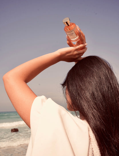 Hayam Perfume with Model holding above head on the beach