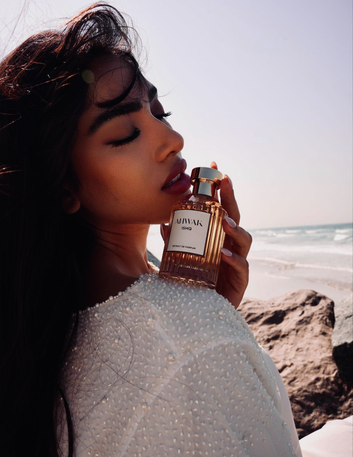 Ishq Perfume with Model holding on shoulder on the Beach